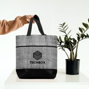 A woman holding an eco-friendly tote bag with a green plant beside it, symbolizing sustainability and reusable branding solutions